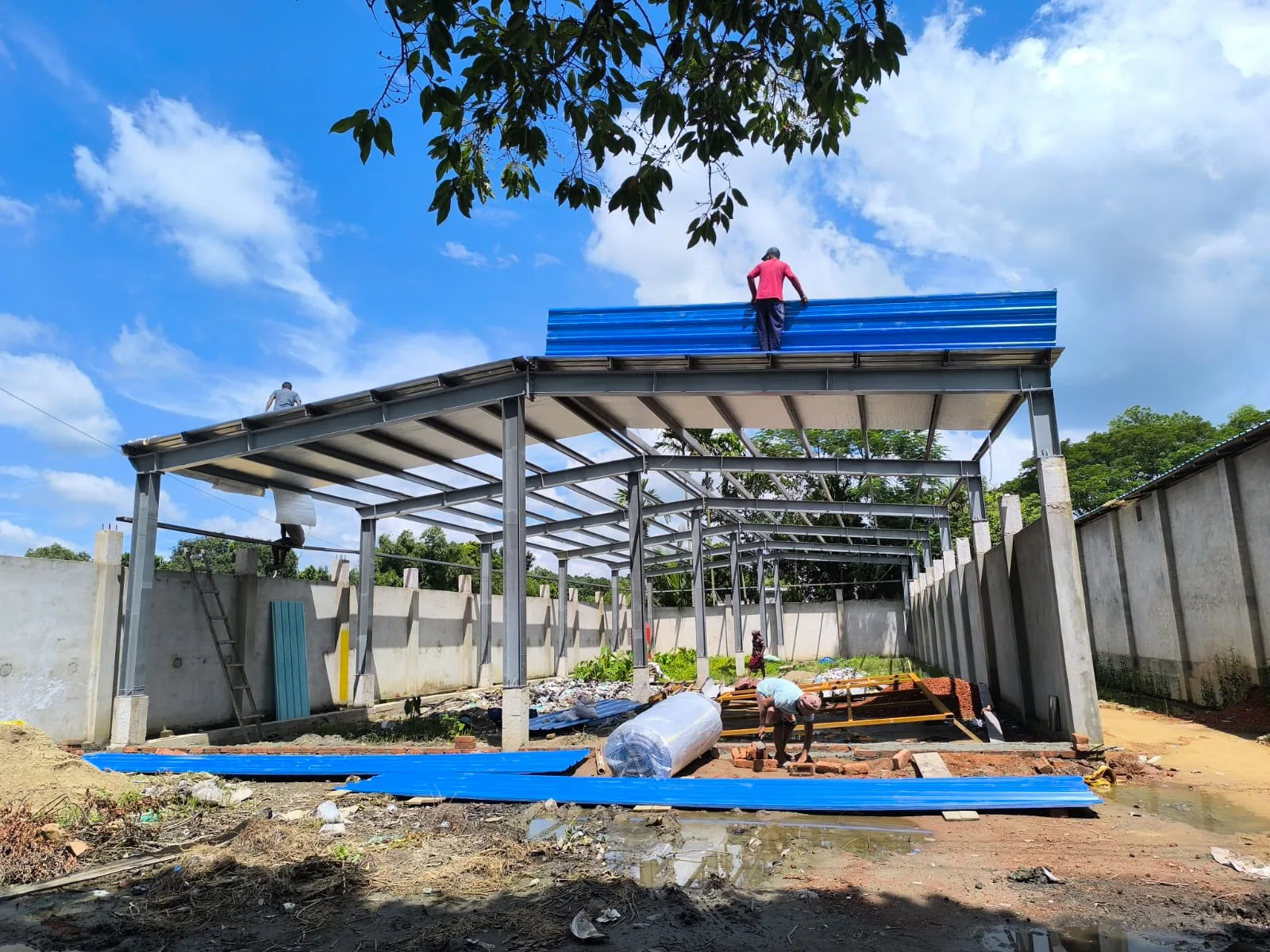 Roofing sheets being installed on a single-storey steel frame